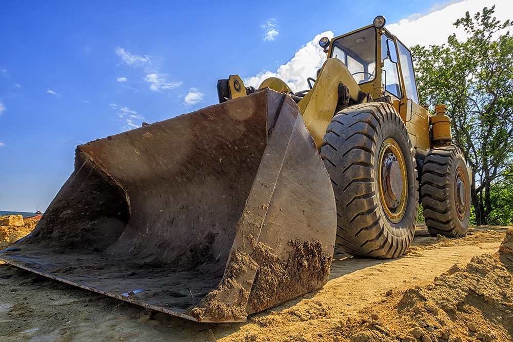day view of a yellow excavator with a shovel at a construction site